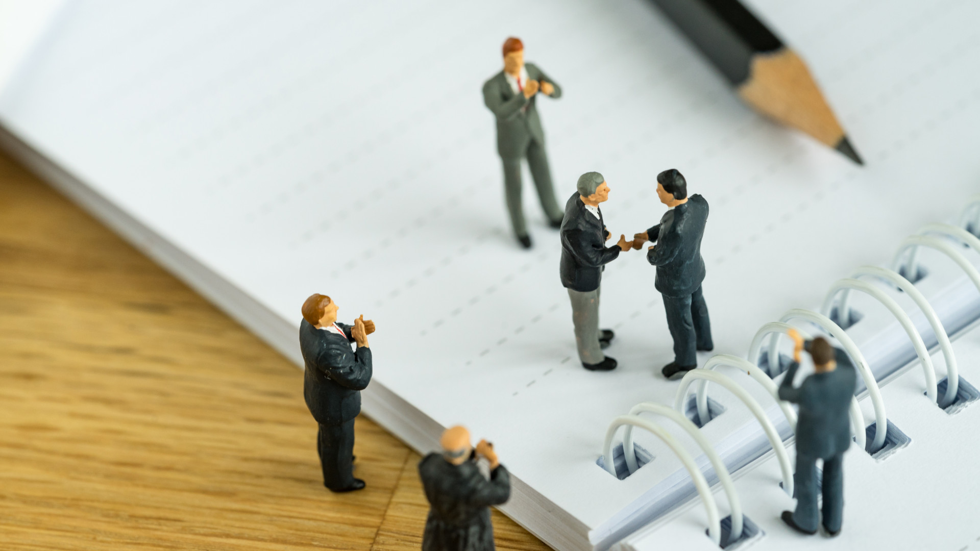 business agreement concept as miniature people businessmen hands